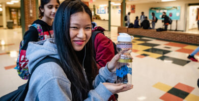 A young high school girl with a Rev Your Bev water bottle