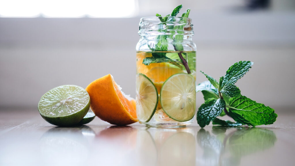 Detox Infused Water with Lemon, Orange, Peppermint, blurred background
